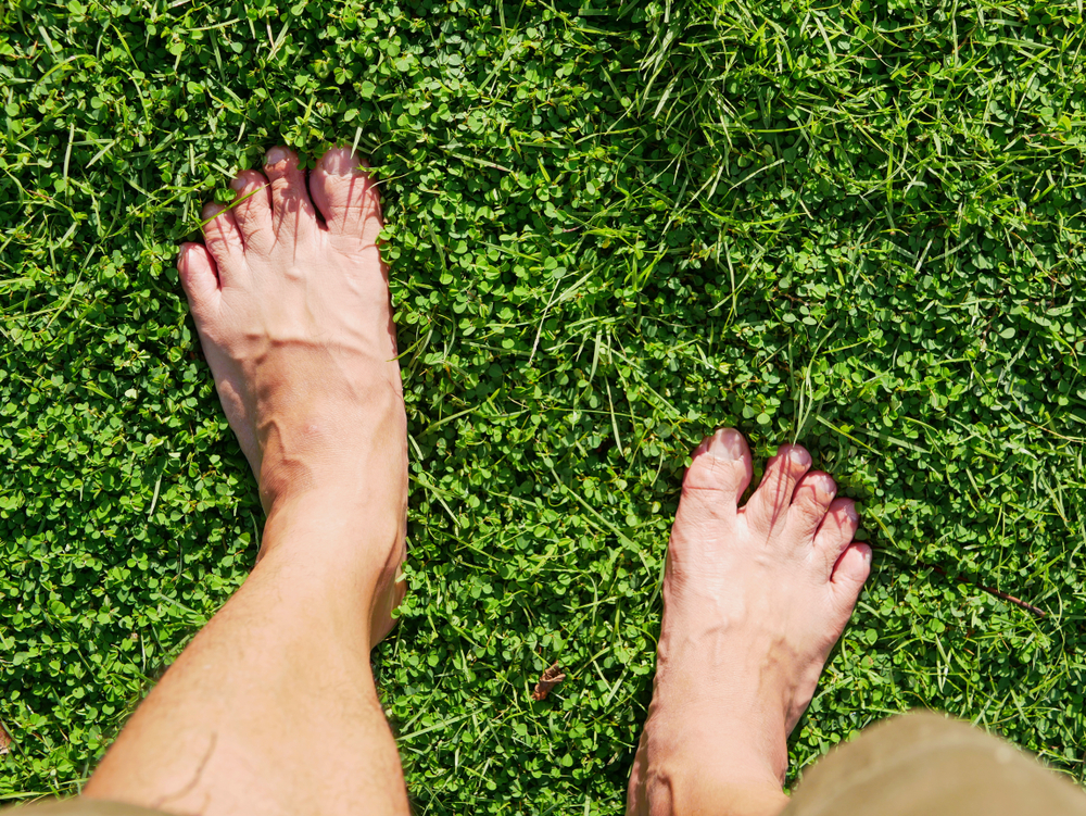 Barefoot man standing on grass